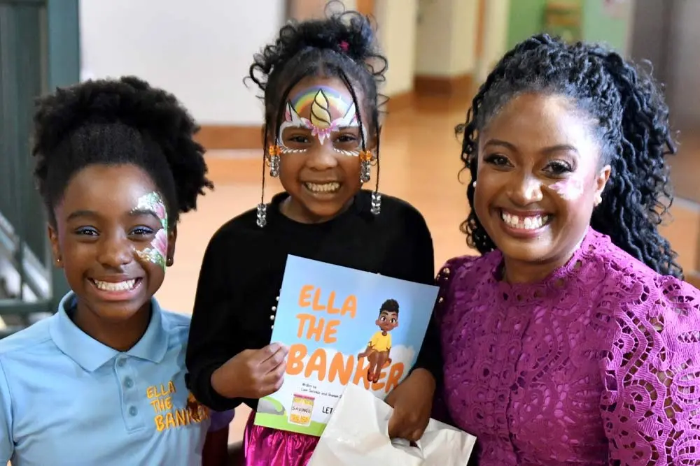 Two girls and a woman gathered together and facing the camera.