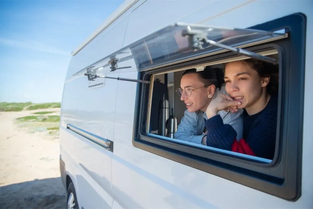 couple looking out an opened window of their RV
