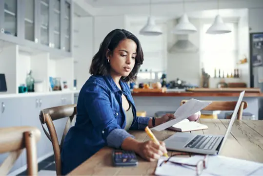 Person working on finances to save for a down payment on a house