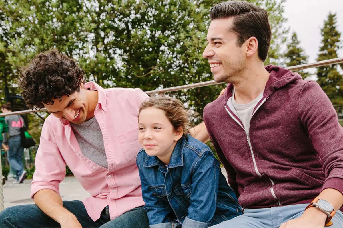 two men with a child at a playground
