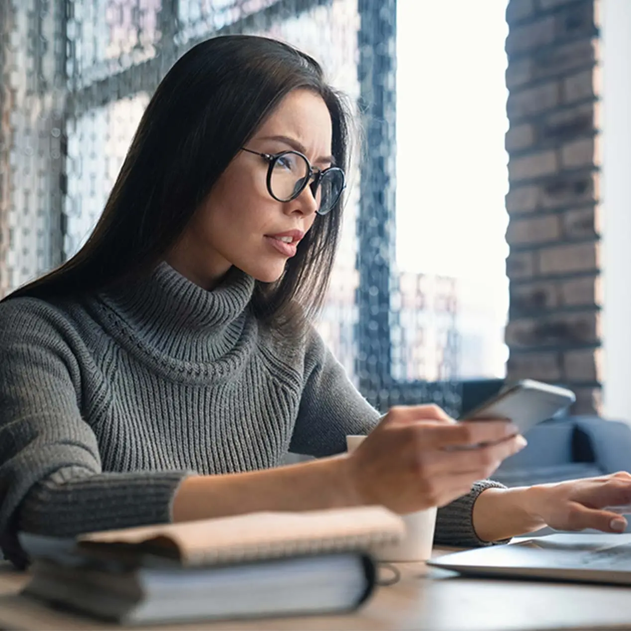 Photo of a women working on computer and cell phone