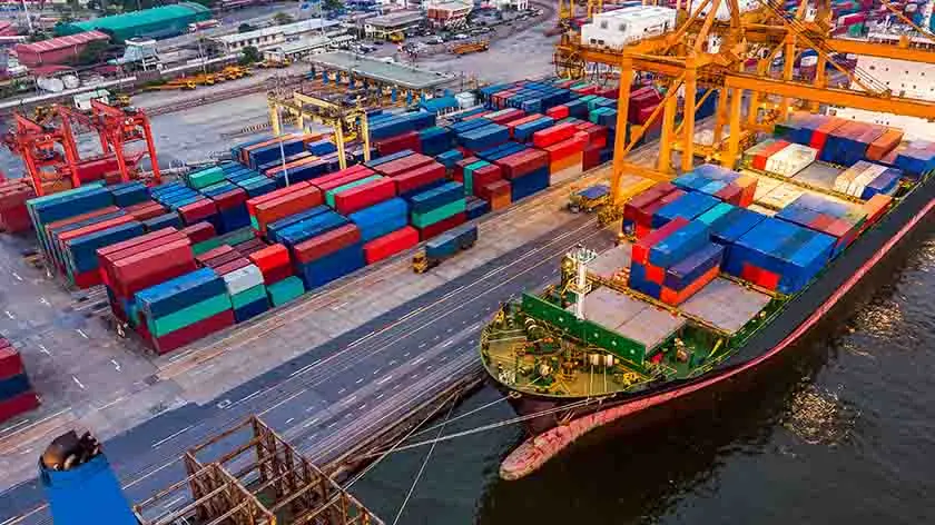 Massive container ship docked in a port, signifying global trade and economics