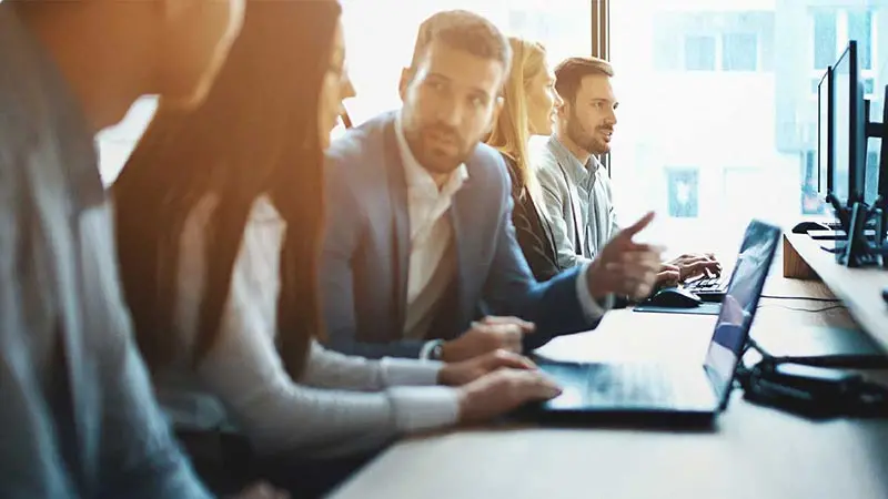 Five business colleagues at a table discussing direct lending market trends