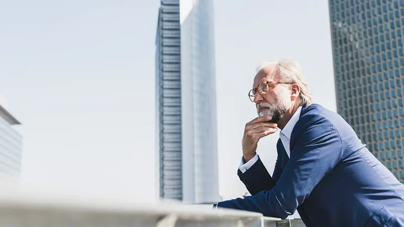Businessman looks out over the city and ponders the benefits of a third-party primary settlement agent.