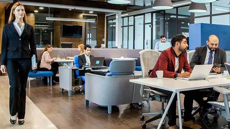 Eight business people working in a futuristic office lounge