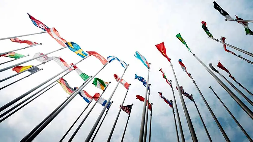 photo of Flags of more than 25 countries flying in the wind, signifying global economic growth.