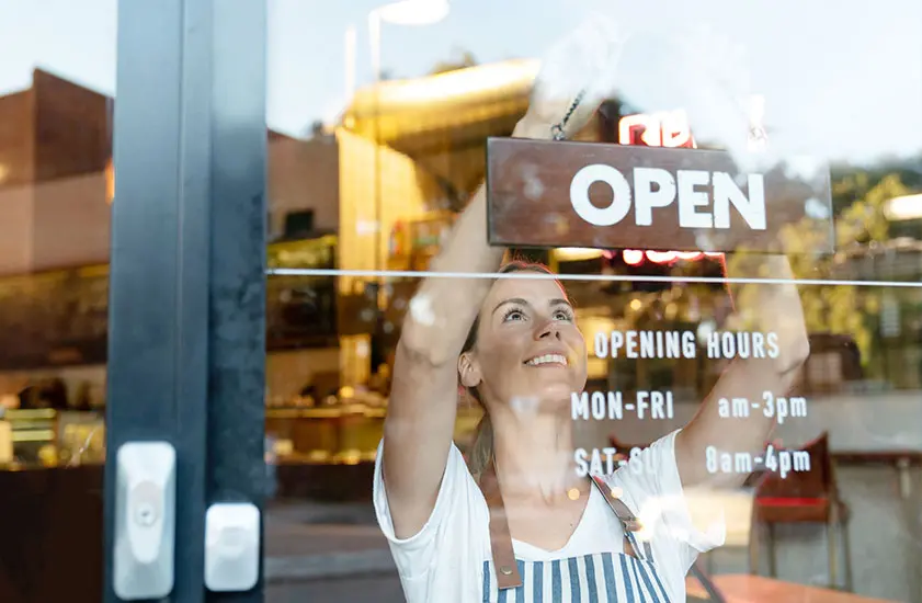 A phot of a shop worker hanging up a sign