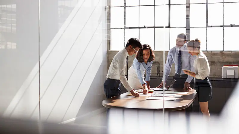 Four colleagues around a table discussing the role of an asset custodian
