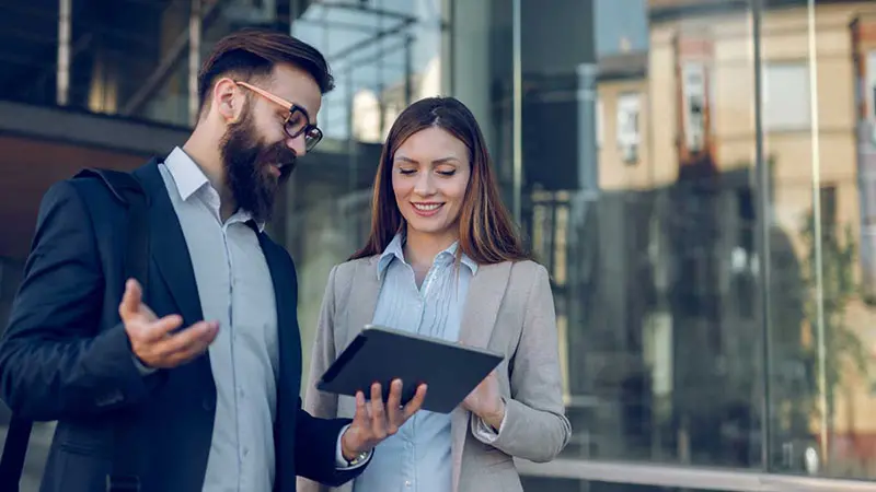 Man and woman looking at tablet discussing debt issuance.