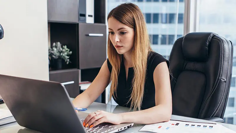 Young woman looking up card optimization on her laptop