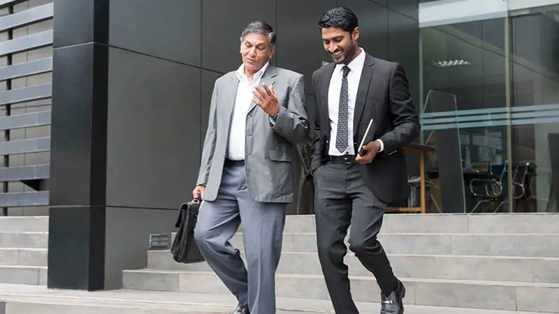 Two investing professionals walking down stairs outside a building and discussing ETCs