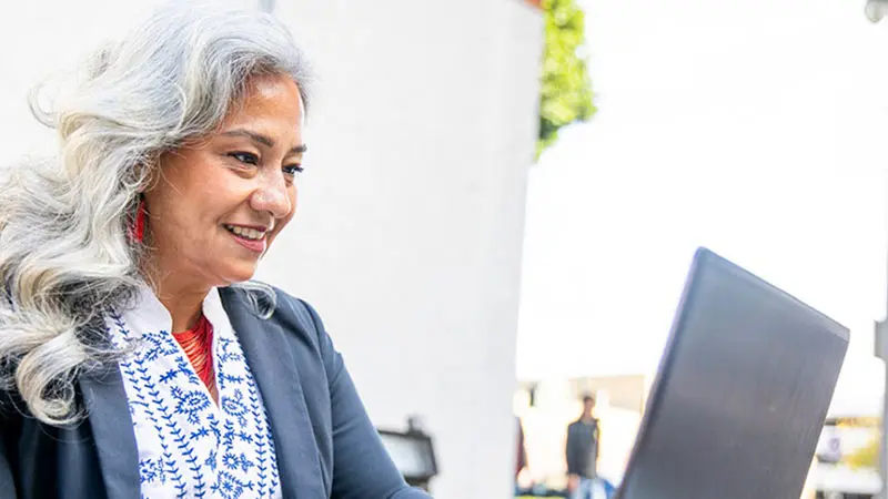 Woman using laptop to research FX hedging