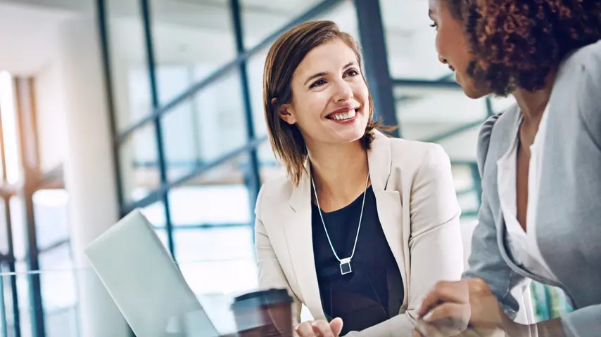 Two people sitting at a desk discussing virtual credit cards and virtual card payments.