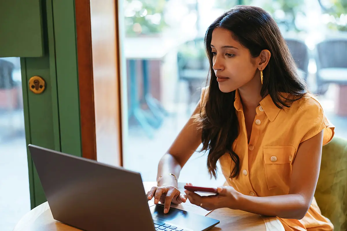 woman in a yellow shirt looking at a computer