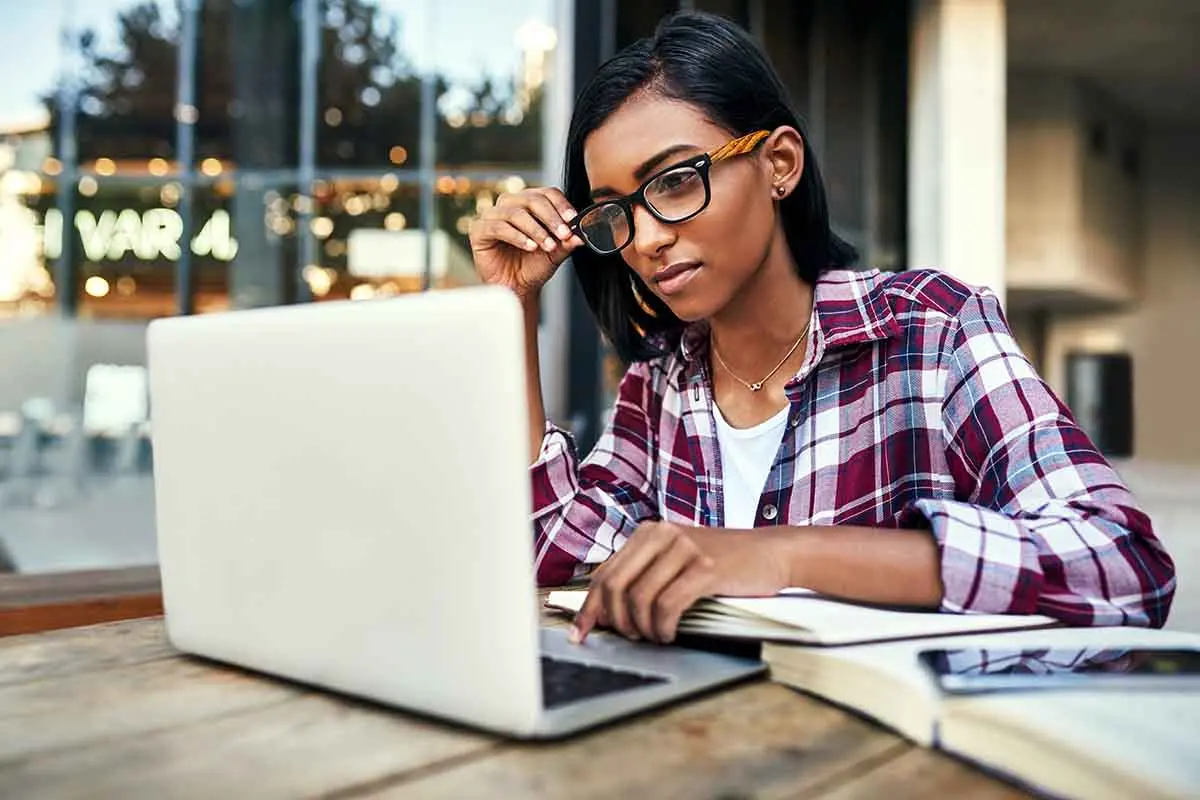 woman wearing glasses looking at her laptop