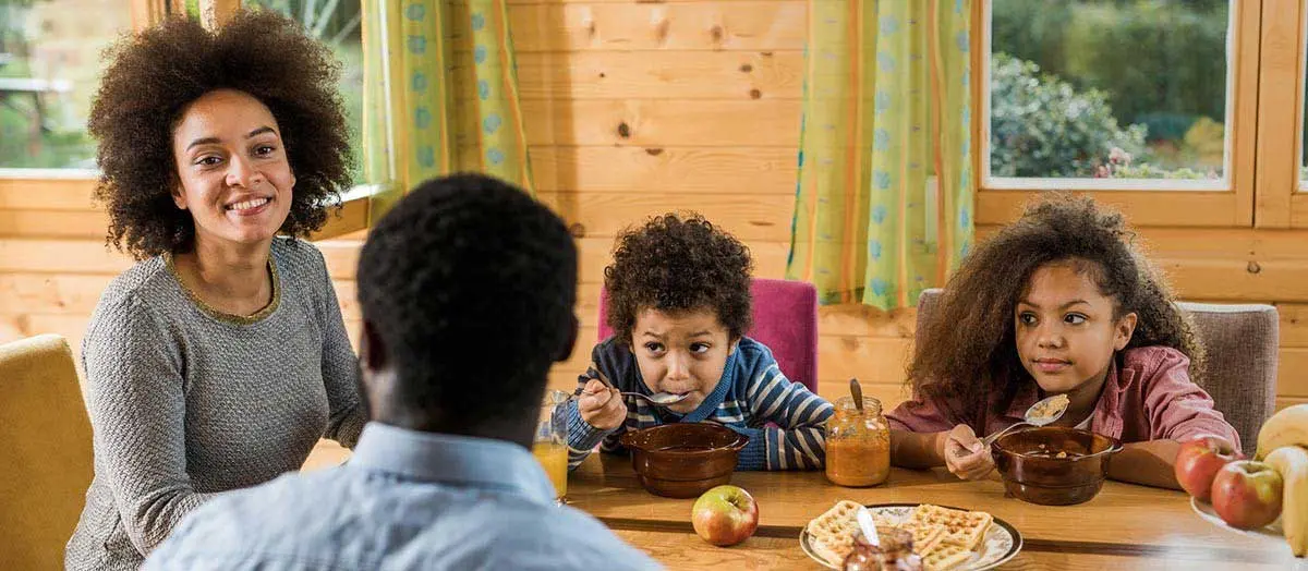 a woman with several children at the dining room table