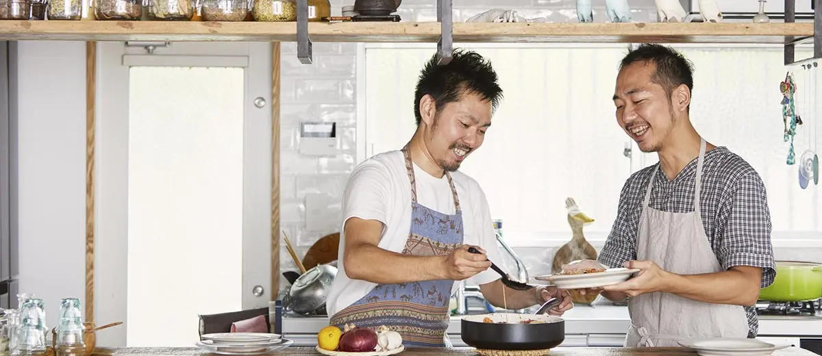 two men cooking together in a kitchen
