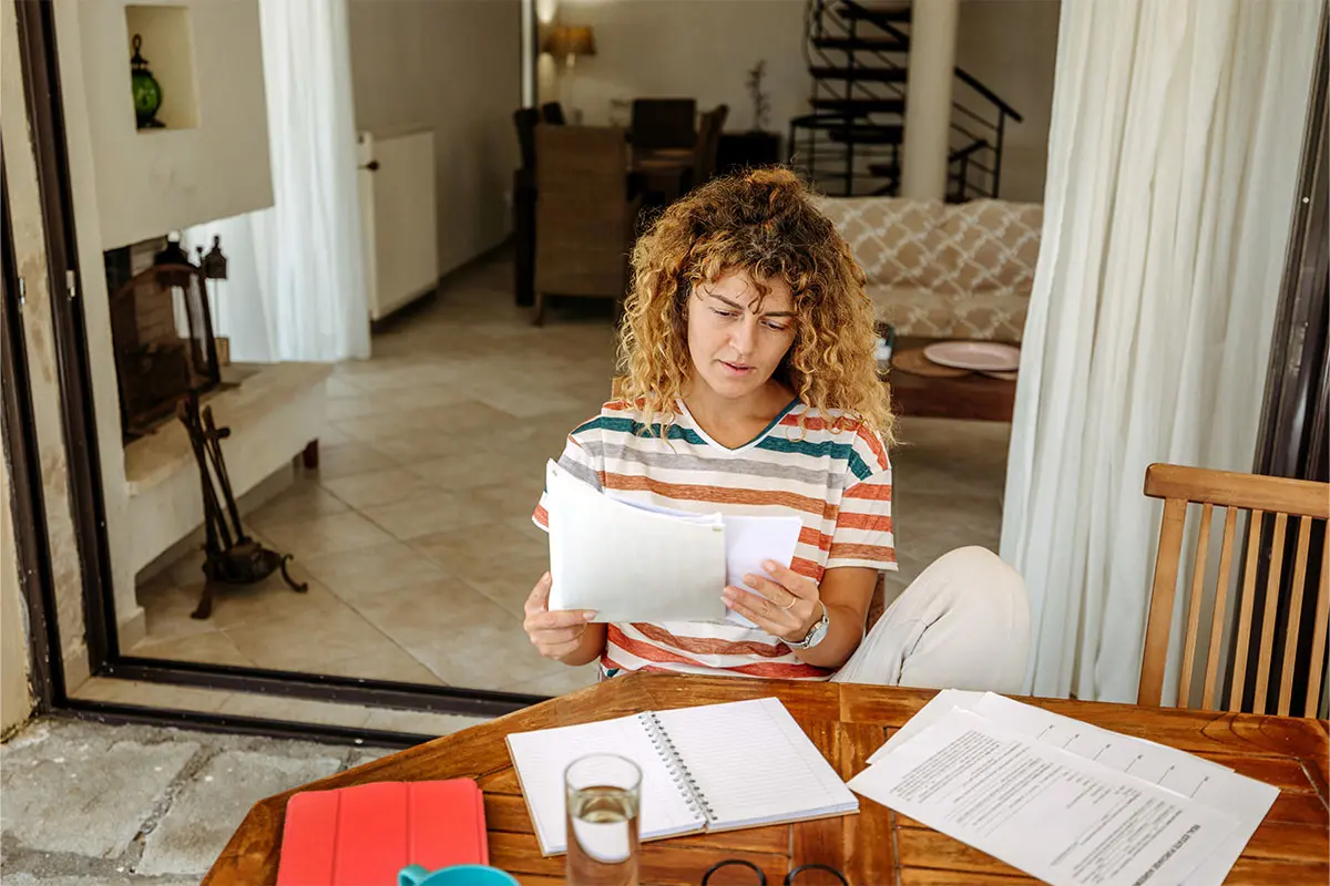 woman in a striped shirt working at a kitchen table
