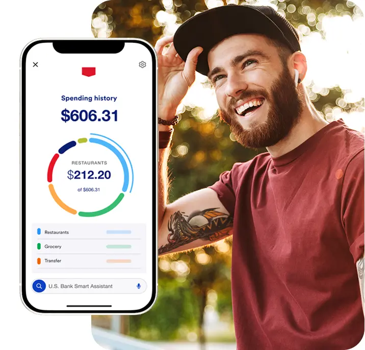 Student smiling next to checking account spending history view in the U.S. Bank mobile app 