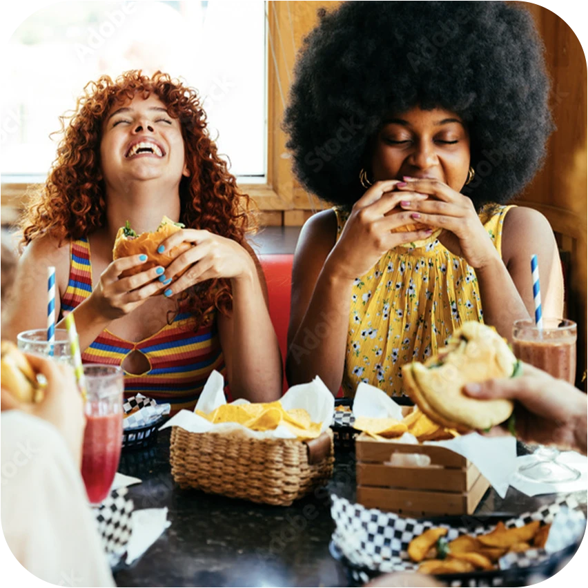 Two teens enjoying a humorous moment while eating out
