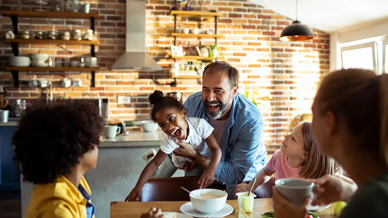 family laughing around breakfas table