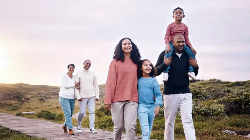 Parents walking with their kids while grandparents walk behind, arm in arm