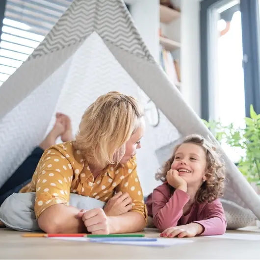 Mom and daughter playing in a fort in their living room
