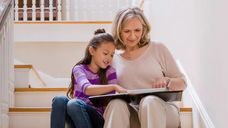grandmother and grandaughter look at photo album