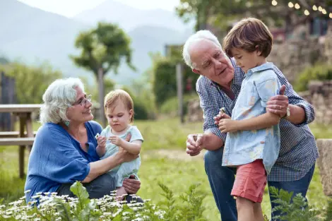 Grandma and grandpa in the flower garden with their two grandchildren