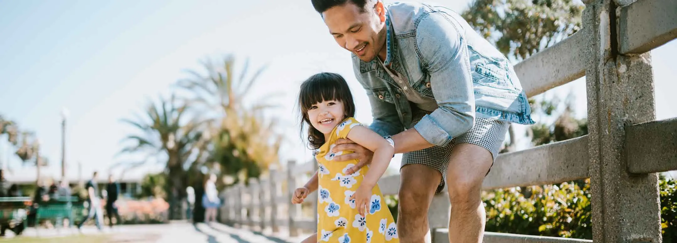 father teaching young daughter how to skateboard