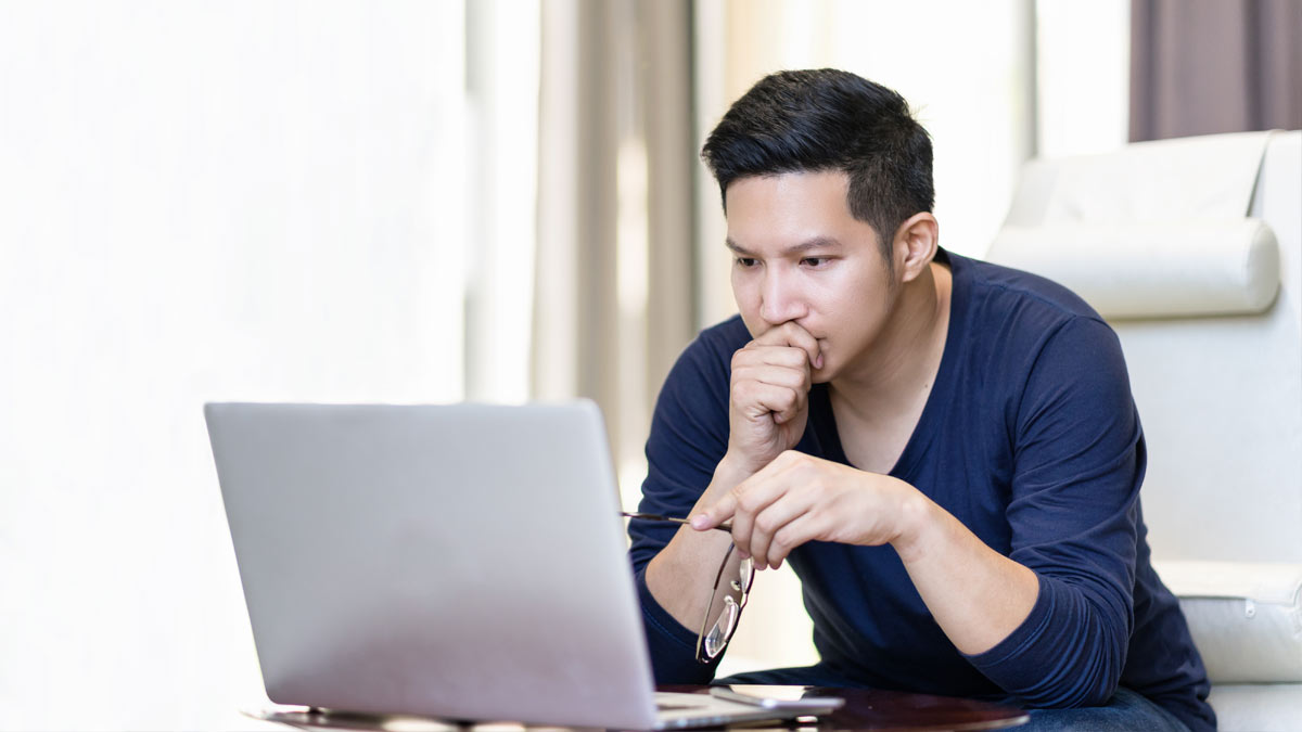 man concentrating looking at laptop