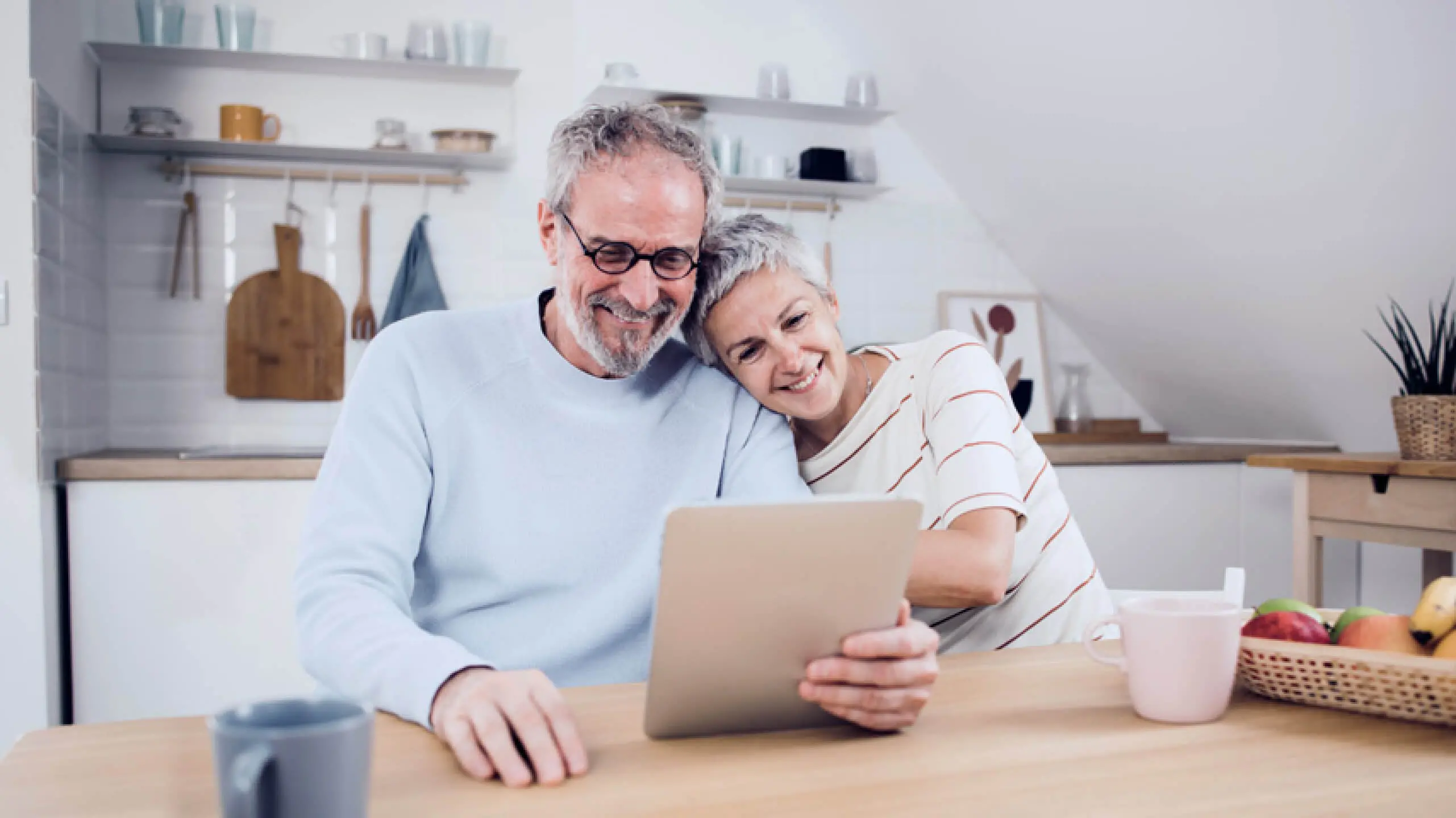 Older man and woman doing retirement calculations at their kitchen table
