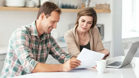young couple discussing portfolio over kitchen counter