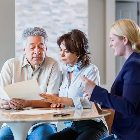 Married couple discussing trusts with an advisor at their kitchen table