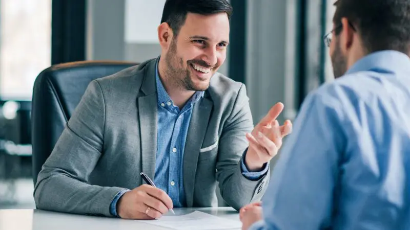 Younger man in his financial advisor's office discussing IRA options  