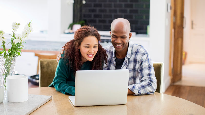 smiling couple using laptop