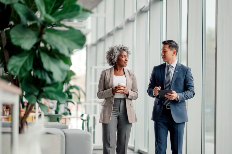 photo two people walking and talking in modern office