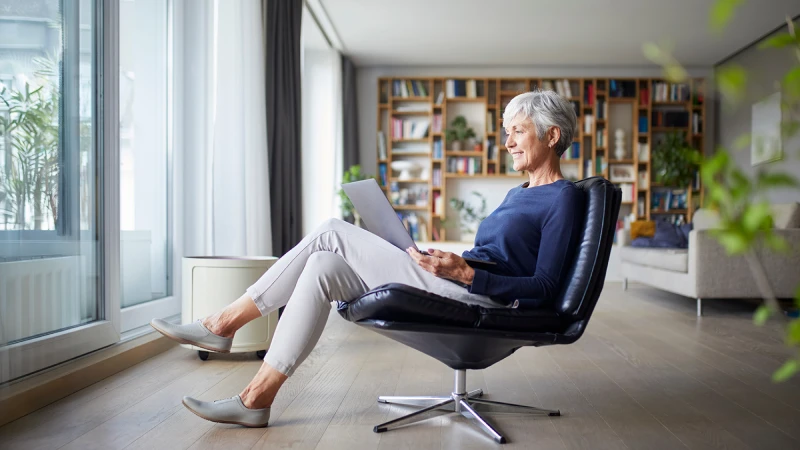 Older woman in an office chair reading about retirement planning  