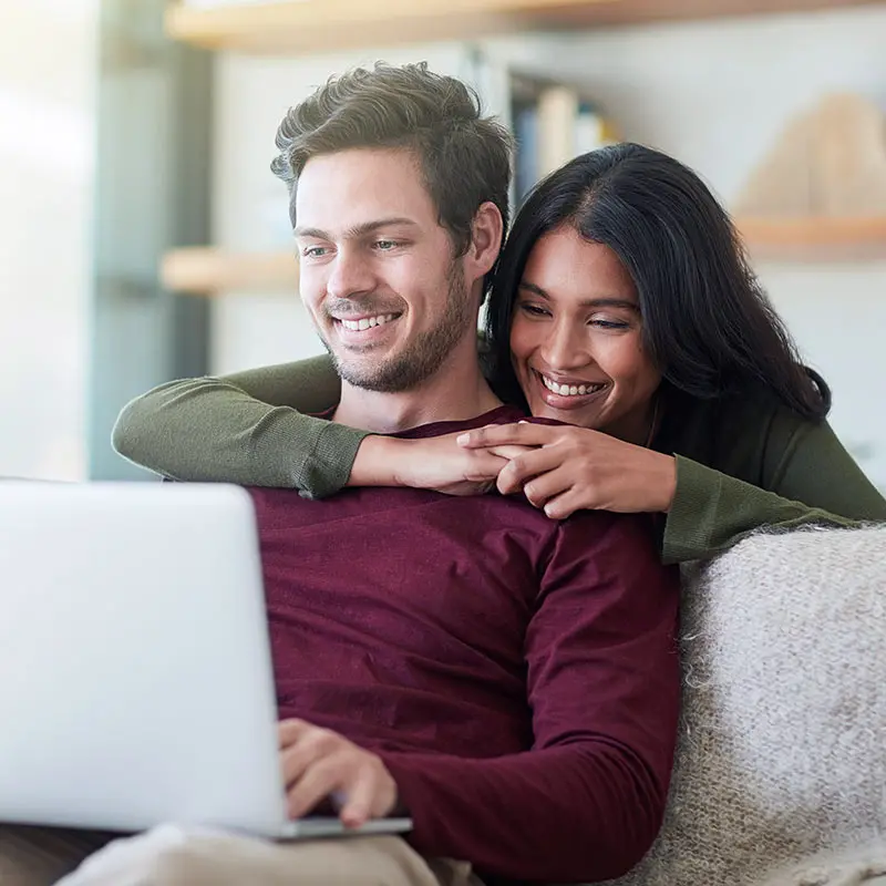 Young couple looking at their portfolio on a laptop 