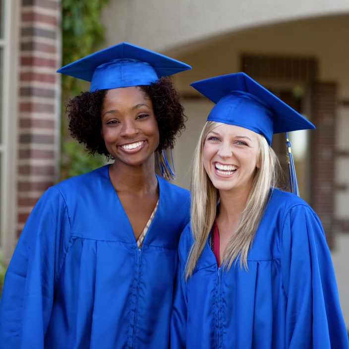 two female graduates standing together