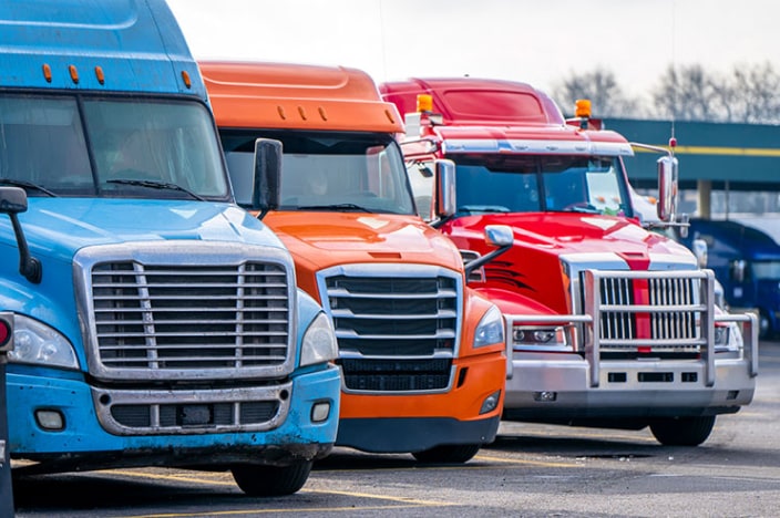 Three 18-wheelers parked next to each other.