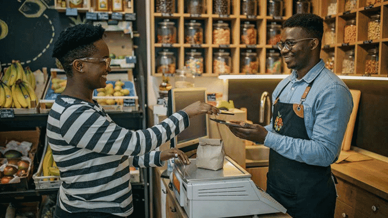 Customer at a grocery store paying the clerk.