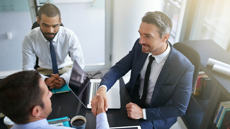 Businessmen shaking hands in an international bank office