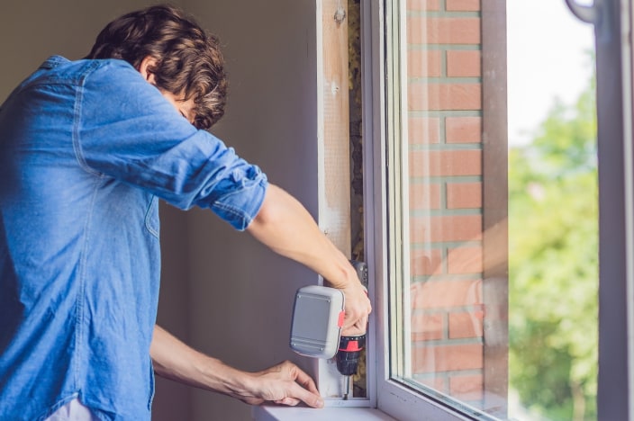 Man using drill on window sill