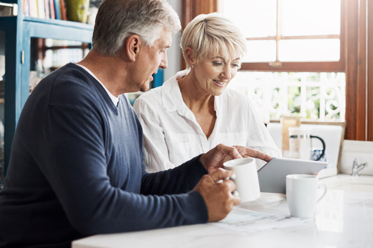 Couple with iPad in kitchen